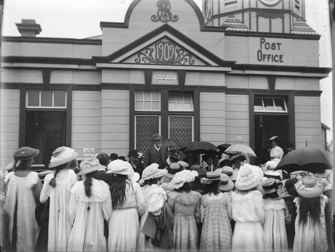 Black and white photograph of a group in front of the post office building.